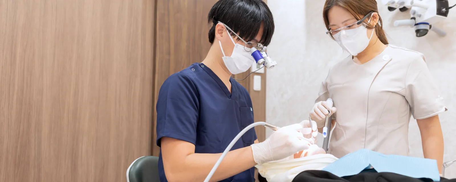口腔外科処置を行う院長とスタッフ